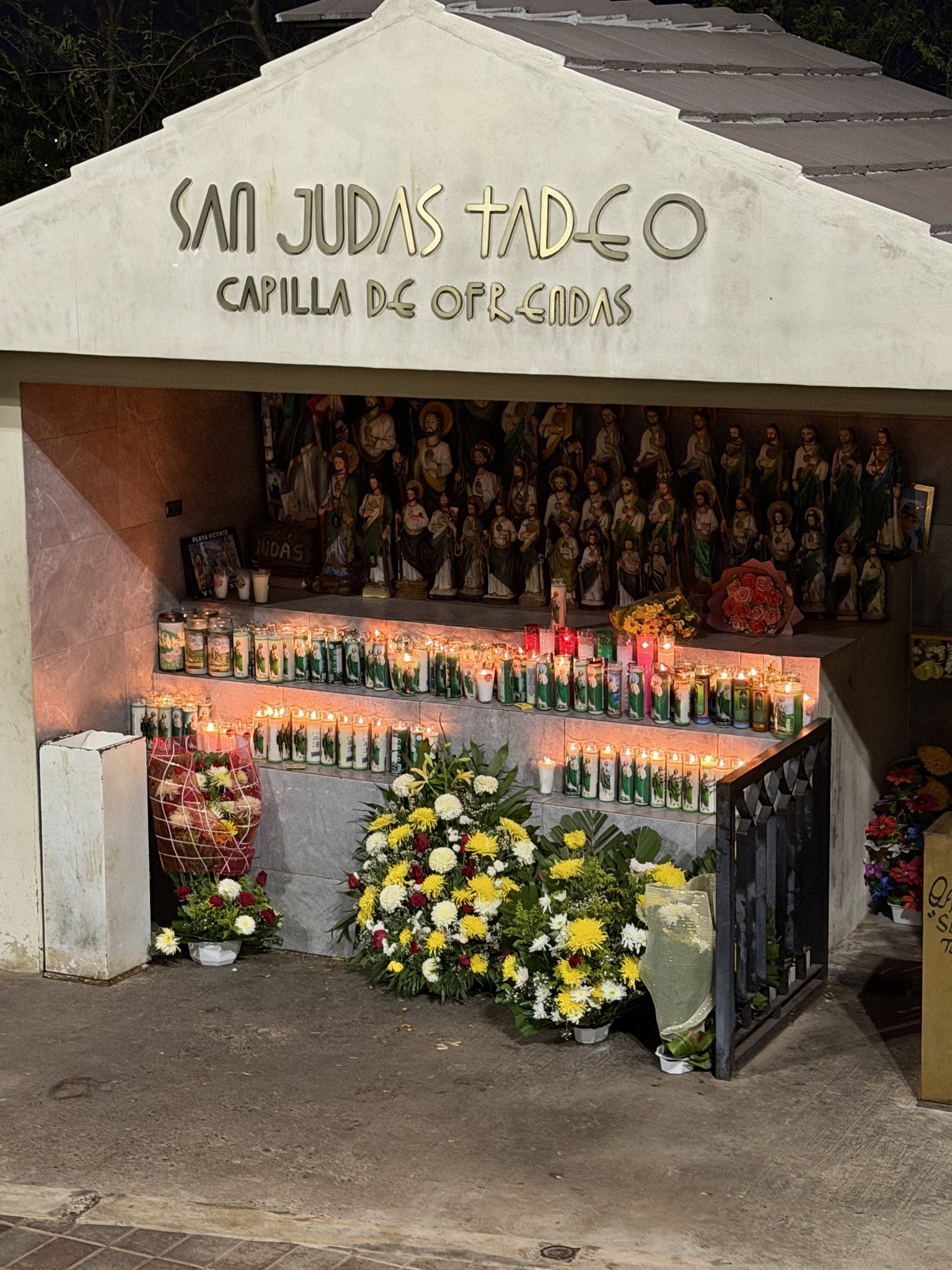 Capilla de ofrendas con veladoras y flores en Badiraguato